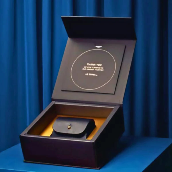 A black flip top magnetic lock box with a leather case inside. The box is open and the case is visible. The box has a message inside that reads "Thank you. We look forward to our journey together. LB Tone."