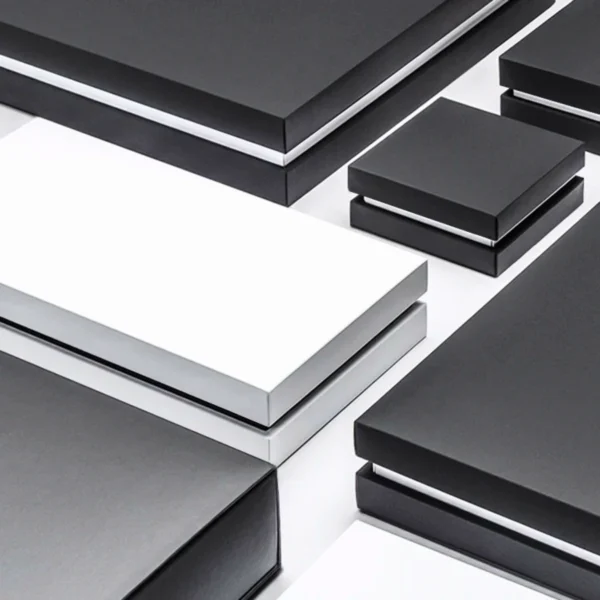 A variety of black, white and grey partial cover rigid boxes with silver accents.