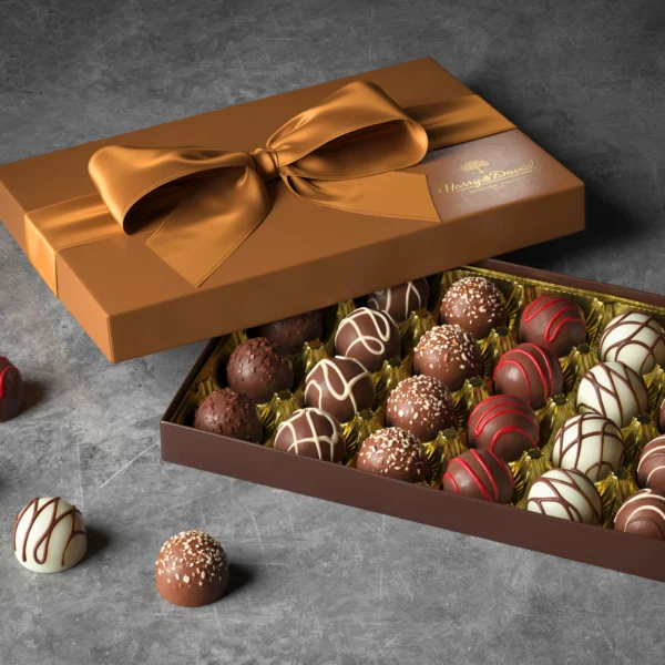 A box of chocolate treats tied with a bow and a grey background.