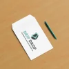 Branded envelope with Drip Drop logo and a pen on a wooden table.