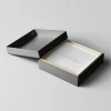 Open black two-piece rigid box with a quote inside.