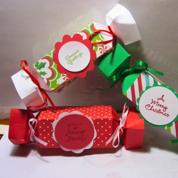 A set of decorative holiday crackers in festive colors with cheerful labels, arranged creatively on a surface.