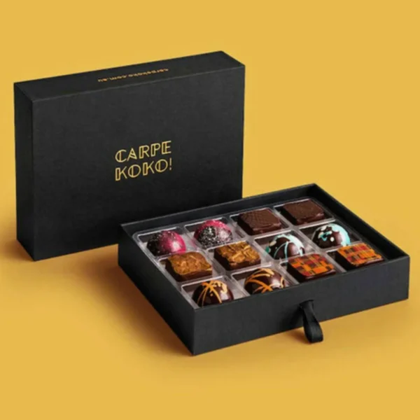 Black chocolate box with assorted chocolates and a yellow background.
