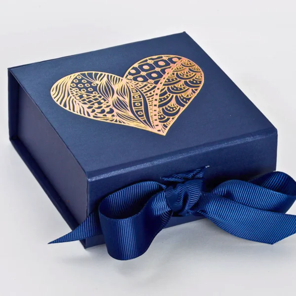 Navy gift box adorned with a decorative gold heart design and ribbon.