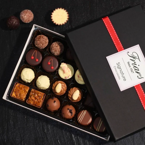 An elegant chocolate box open to reveal a variety of chocolates.
