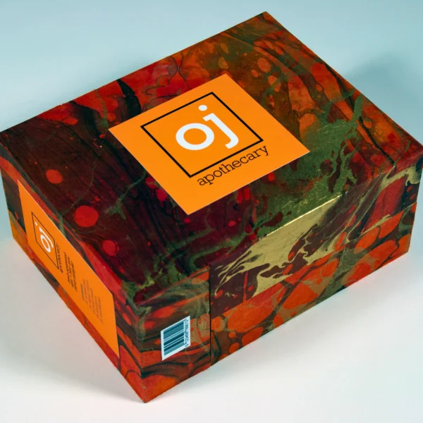 Stylish packaging box with an orange label and vibrant marbled design.