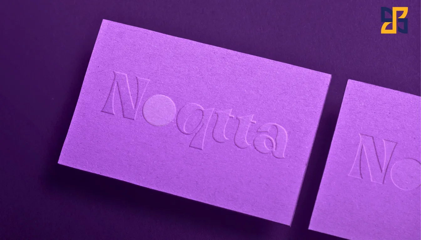 Embossed purple business card with the name 'Noquta' showcasing texture and detail.