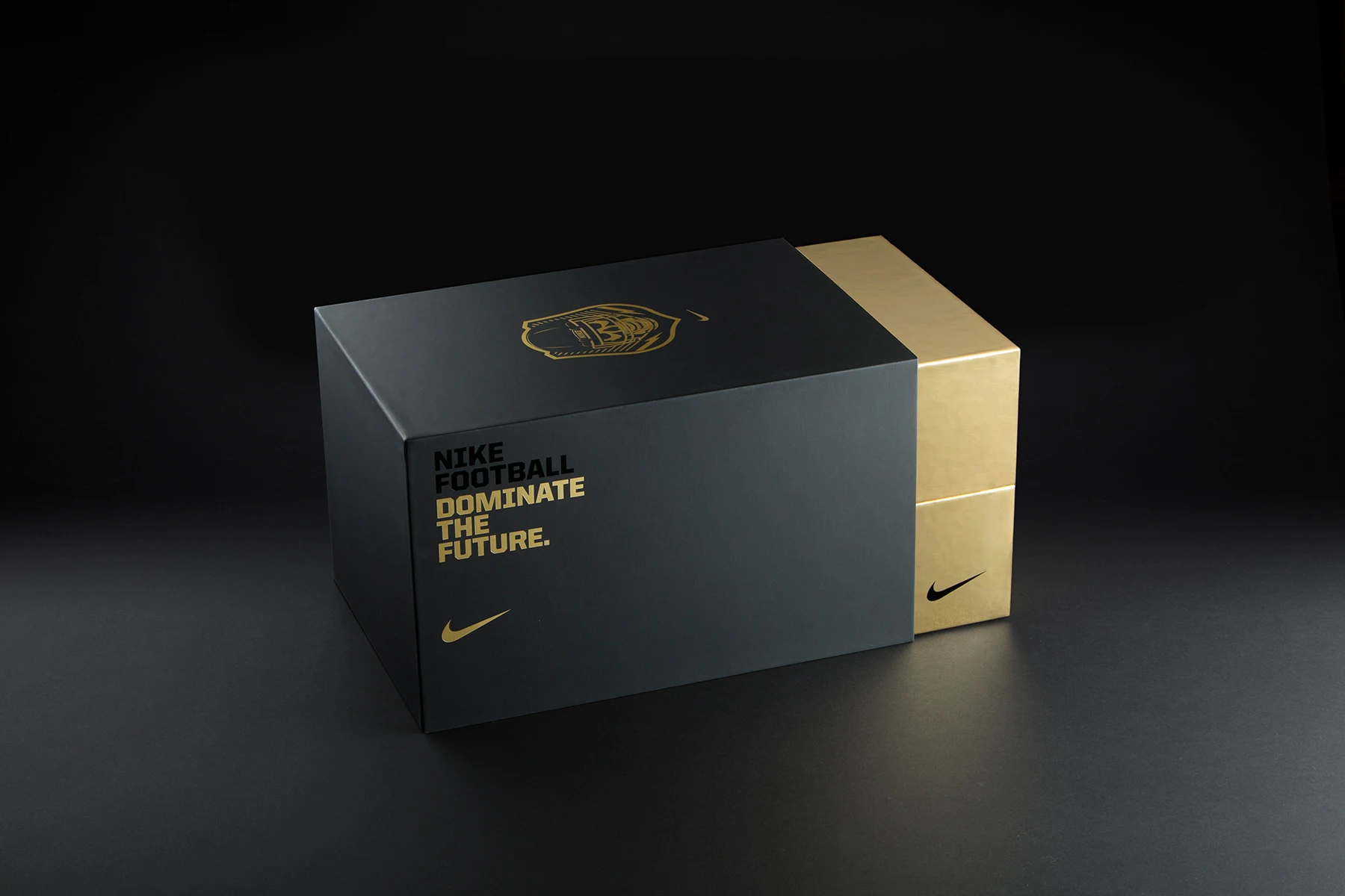 A stylish black and gold Nike football shoe box featuring the text "NIKE FOOTBALL DOMINATE THE FUTURE" and a Nike logo.